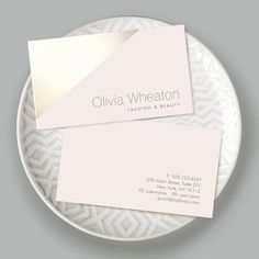 two business cards sitting on top of a white plate