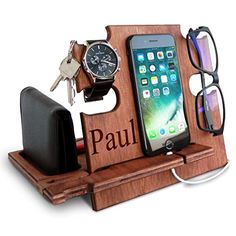 an iphone, watch, and glasses are on a wooden stand with a cell phone