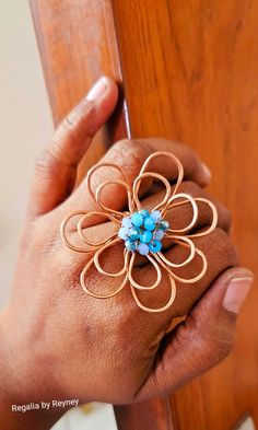 a woman's hand holding onto a wooden door handle with a flower design on it