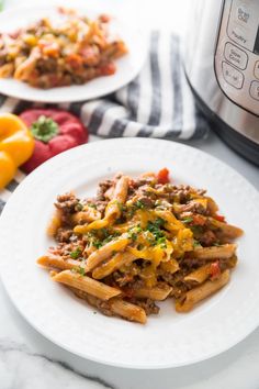 two plates of pasta with meat and vegetables next to an instant pot pressure cooker