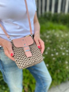 a woman is holding a small purse in her hands