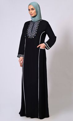 Introducing our exquisite Floral Embroidered Abaya, a timeless piece that seamlessly blends elegance with modern style. The intricate embroidery adds a touch of femininity and sophistication to the garment, making it perfect for any special occasion or everyday wear. Adding to its charm, the abaya showcases colored piping along the princess seams, enhancing its silhouette and creating a flattering, elongating effect. The piping adds a subtle pop of color, elevating the overall design and making Modest Black Kaftan For Eid, Traditional Black Embroidered Thobe, Traditional Black Abaya With Floral Embroidery, Elegant Black Abaya With Floral Embroidery, Elegant Long Sleeve Abaya With Embroidered Border, Traditional Black Long Sleeve Abaya, Traditional Long Sleeve Black Abaya, Elegant Black Embroidered Kaftan, Elegant Embroidered Black Abaya