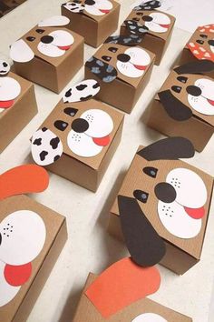 cardboard boxes with dog faces on them sitting on a table next to paper cut outs