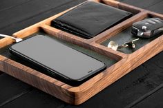 a cell phone and wallet in a wooden tray