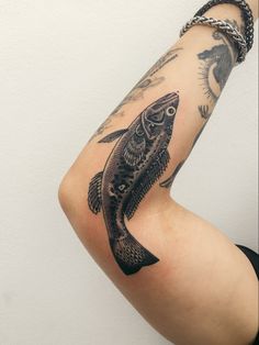 a person with a fish tattoo on their arm