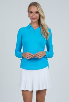 This flattering polo top has adjustable ties along the sides to let you create the length and look you choose. This silhouette features our patented Iceƒil Cooling Technology lowering your skin temperature up to five degrees. The mesh inner arm panels provide additional ventilation to keep you cool and dry for all your athleisure activities. UPF 50+ sun protection protects you from the sun along with anti-bacterial and moisture wicking properties allows you to look and feel your best on the hott Fitted Long Sleeve Golf Tops, Collared Tops For Golf, Fitted Long Sleeve Tops For Golf, Fitted Tops For Golf, 4-way Stretch Tops For Golf, Blue Long Sleeve Tops With 4-way Stretch, Golf Collection, Blue Candy, Hot And Humid