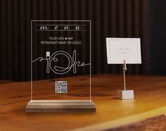 a clear acrylic award sitting on top of a wooden table next to a white sign