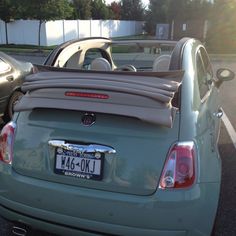 two cars parked in a parking lot with their hoods down and the back end open