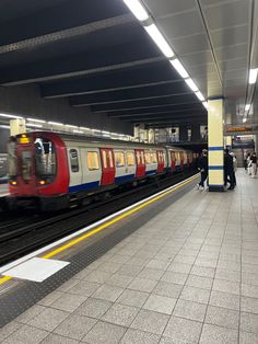 a subway station with people waiting for the train