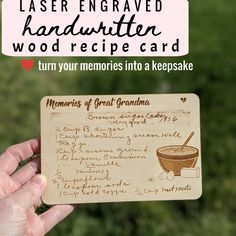 a hand holding up a wooden card with writing on it that says, laser engraved handwritten wood recipe card turn your memories into a keepsake