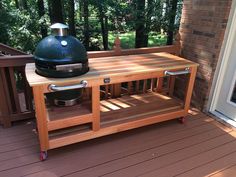 a bbq grill sitting on top of a wooden deck next to a sliding glass door