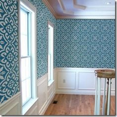 an empty room with blue wallpaper and wooden floors