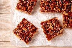 several pieces of pecan bar sitting on top of wax paper