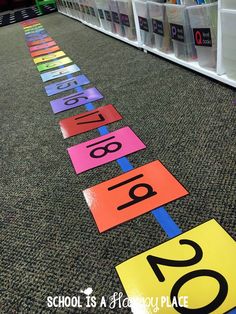 colorful signs on the floor in front of bookshelves with numbers painted on them