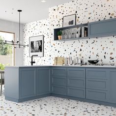 a kitchen with blue cabinets and patterned wallpaper