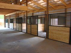 the inside of a horse barn with stalls