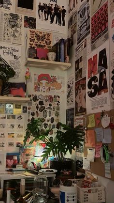 a cluttered desk with lots of papers on the wall and a potted plant