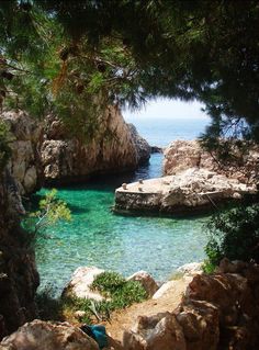 a body of water surrounded by rocks and trees