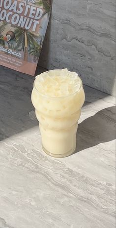 a drink sitting on top of a table next to a book about toasted coconut