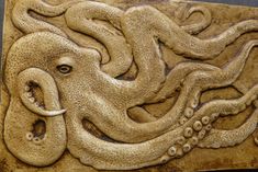 an intricately carved tile with octopus's head and tentacles on the outside of it