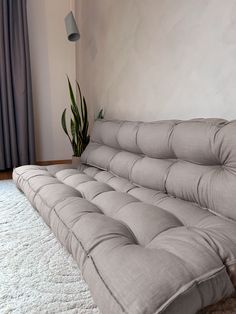 a couch sitting on top of a white rug next to a window