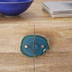 a wooden table with a blue bowl on it and a book next to it that is open