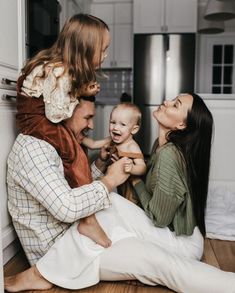 a man and woman are sitting on the floor with a baby