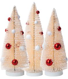 three white christmas trees with red and white ornaments