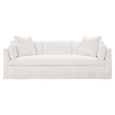 a white couch with four pillows on it's back and one arm facing the camera