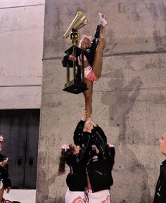 the cheerleaders are doing tricks with their trophies