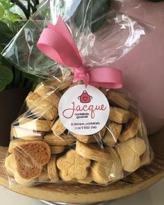 a bag filled with cookies sitting on top of a table next to a potted plant