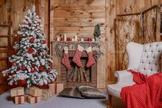 a living room decorated for christmas with stockings on the fire place and a tree in the corner