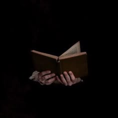 a person reading a book in the dark