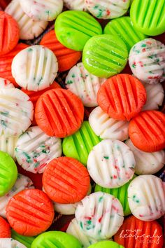 colorful candy cookies are arranged in rows on a table with white and green icing