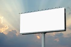 a billboard with birds sitting on it in front of the sun shining through some clouds