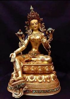 a golden buddha statue sitting on top of a table