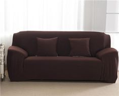 a brown couch sitting next to a window in a living room