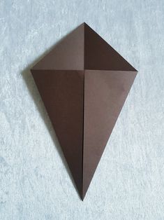 an origami shaped object sitting on top of a white surface