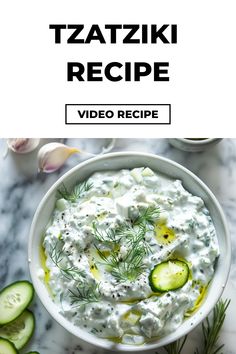 a white bowl filled with cucumber and sour cream dip on top of a marble counter