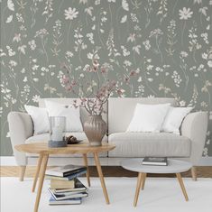 a living room with flowers on the wall and two tables in front of it,