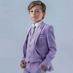 a young boy in a purple suit and white shirt is posing for the camera with his hands on his hips