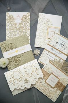 wedding stationery with gold and white paper on top of each other, including the letter glittery