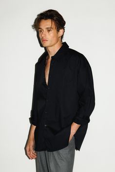 An ultra-crisp button up shirt with the effortless proportions of 90's Wall Street. Worn untucked or half-tucked, this oversized, billowy office staple makes for the ultimate off-duty move. Constructed from 100% pima cotton, a superior high-grade cotton known for it's incredible softness. All Black Button Up Outfit Men, Men Black Shirt Outfit Casual, Men’s Button Up, Men Button Up Shirt Outfit, Black Button Up Shirt Outfit Men, Black Button Up Men, Black Button Up Shirt Outfit, Black Shirt Outfit, Black Shirt Outfits