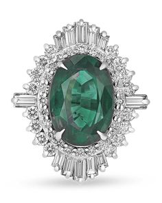 an emerald and diamond ring with white diamonds around the center, set in 18k white gold