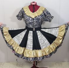 24 KARAT COLLECTION     "  Pentagon " New , women's square dance outfit. It has a v neck blouse with a gold lame ruffle and elastic sleeves. The skirt is very full and has a double ruffle. There are 16 alternating panels . Gold, black and white have been used in the fabric.      This is a One of a Kind creation, never to be made again. It is a size LARGE . It has a waistband from 30" -39" and the skirt length is 23". It is an ample fit. A FREE matching man's tie is included , not the belt. Gold, Square Dance Outfit, Elastic Sleeves, Dance Outfit, Square Dance, Belt Gold, Gold Lame, Square Dancing, Plain Fabric, Outfit Dress