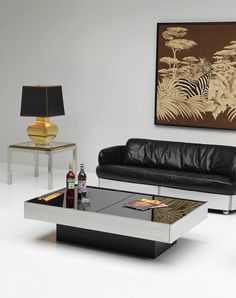 a living room with two couches and a coffee table in front of a painting