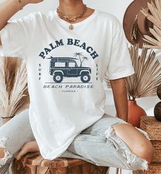 Palm Beach Shirt | Palm Beach Crewneck | Palm Beach Florida | Vintage Florida Shirt | Florida Gifts | Palm Beach Tshirt | Jeep Shirt Women ▹ SIZING AND ITEM DETAILS * T-Shirt sizes are UNISEX. Please check photos for detailed measurements. Try comparing the measurements to your favorite t-shirt that fits just the way you like it! * Main photo shows the White t-shirt. Design can also be printed on Athletic Heather. Clicking on each color in the dropdown box will show that color's photo. Design is printed in Navy for all shirt colors. * White is 100% combed and ring-spun cotton * Athletic Heather is 90% combed and ring-spun cotton, 10% polyester * Fabric weight: 4.2 oz (142 g/m2) * Pre-shrunk fabric * Side-seamed construction * Design is printed using direct-to-garment (DTG) print on Bella C Casual White T-shirt For Vacation, Casual Crew Neck T-shirt For Vacation, White Tropical T-shirt For Beach Season, Casual Crew Neck Top With Palm Tree Print, Summer Vacation Tops With Palm Tree Print, Summer Tops With Palm Tree Print For Vacation, White Vsco T-shirt For Beach, Casual Vacation Tops With Palm Tree Print, Beachy Palm Tree Print Tops For Vacation