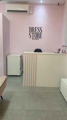 the front desk of a dress store with pink walls