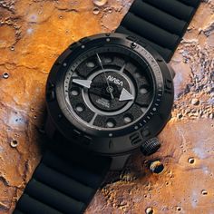 Whether it’s deep in the ocean or deep in space, the Xeric Voyager Automatic can withstand 100 times the pressure of Earth’s atmosphere. With this 1,000 meter depth rating, Xeric also integrated a helium escape valve into the case, preventing a pressure differential that can occur during deep dives.The watch is powered by the self-winding TMI NH38 automatic movement. As you wear it, the rotor winds the mainspring, creating stored mechanical energy that powers the watch. The movement is housed in Voyager Spacecraft, Breitling Watches Mens, Mechanical Energy, Rolex Watches For Men, Breitling Watches, Nasa Space, Modern Watches, G Shock Watches, In The Ocean