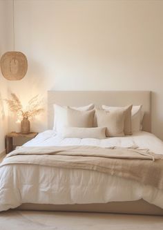 a bed with white linens and pillows in a bedroom